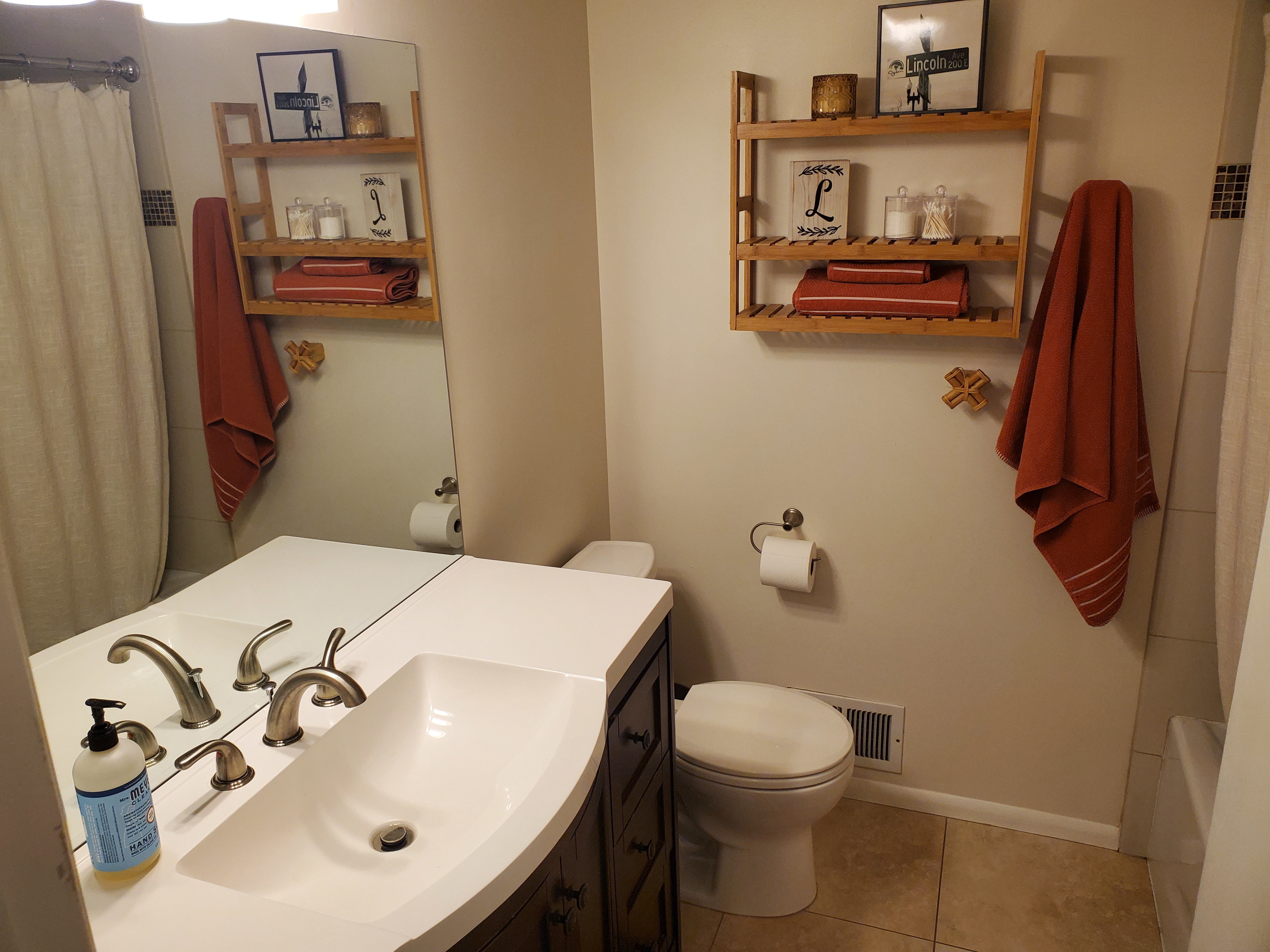 Bathroom featuring a dark wood-finish vanity with a white countertop and integrated rectangular sink