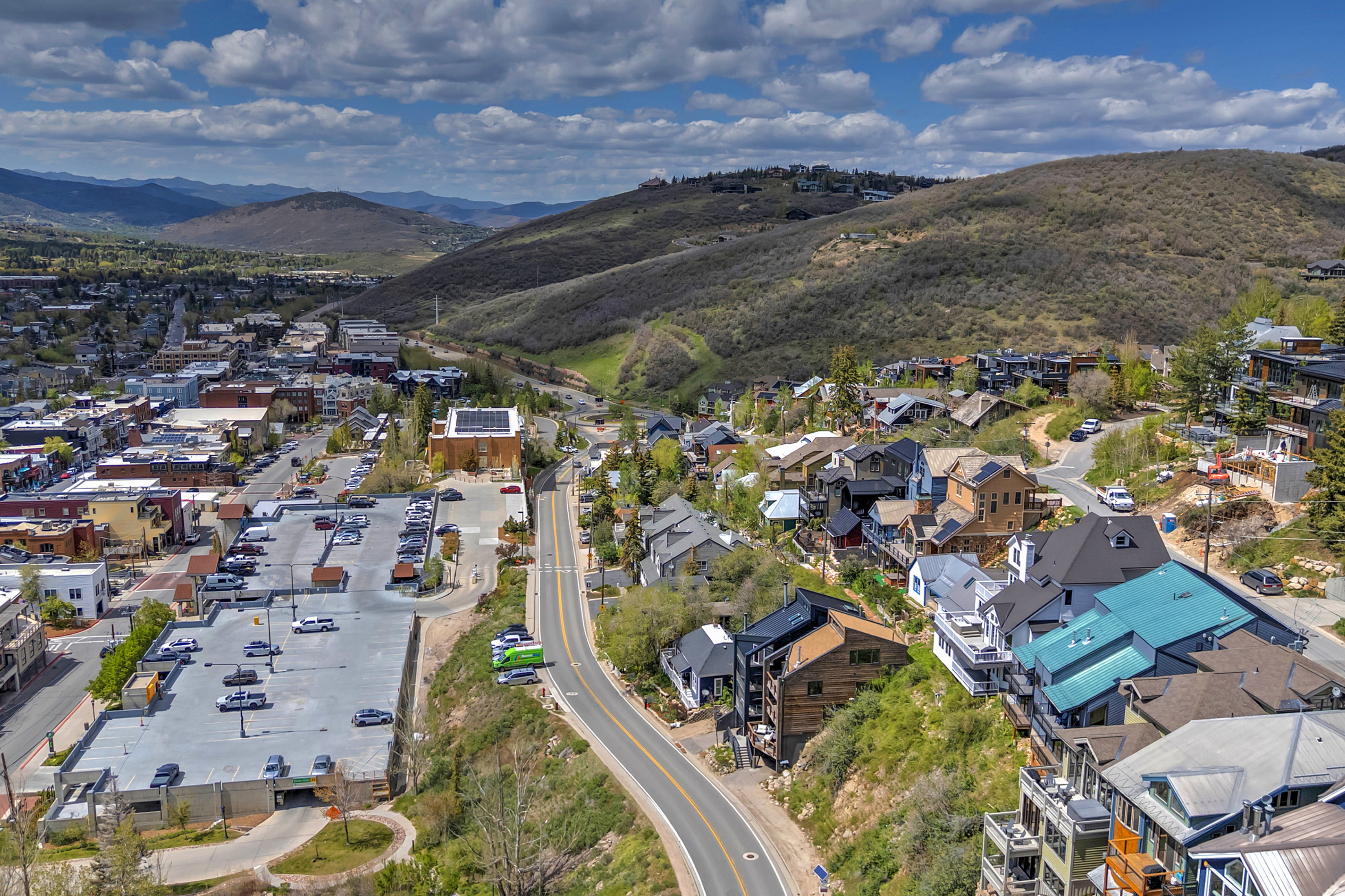 Aerial perspective of a hillside community featuring multi-level residences with diverse architectural styles