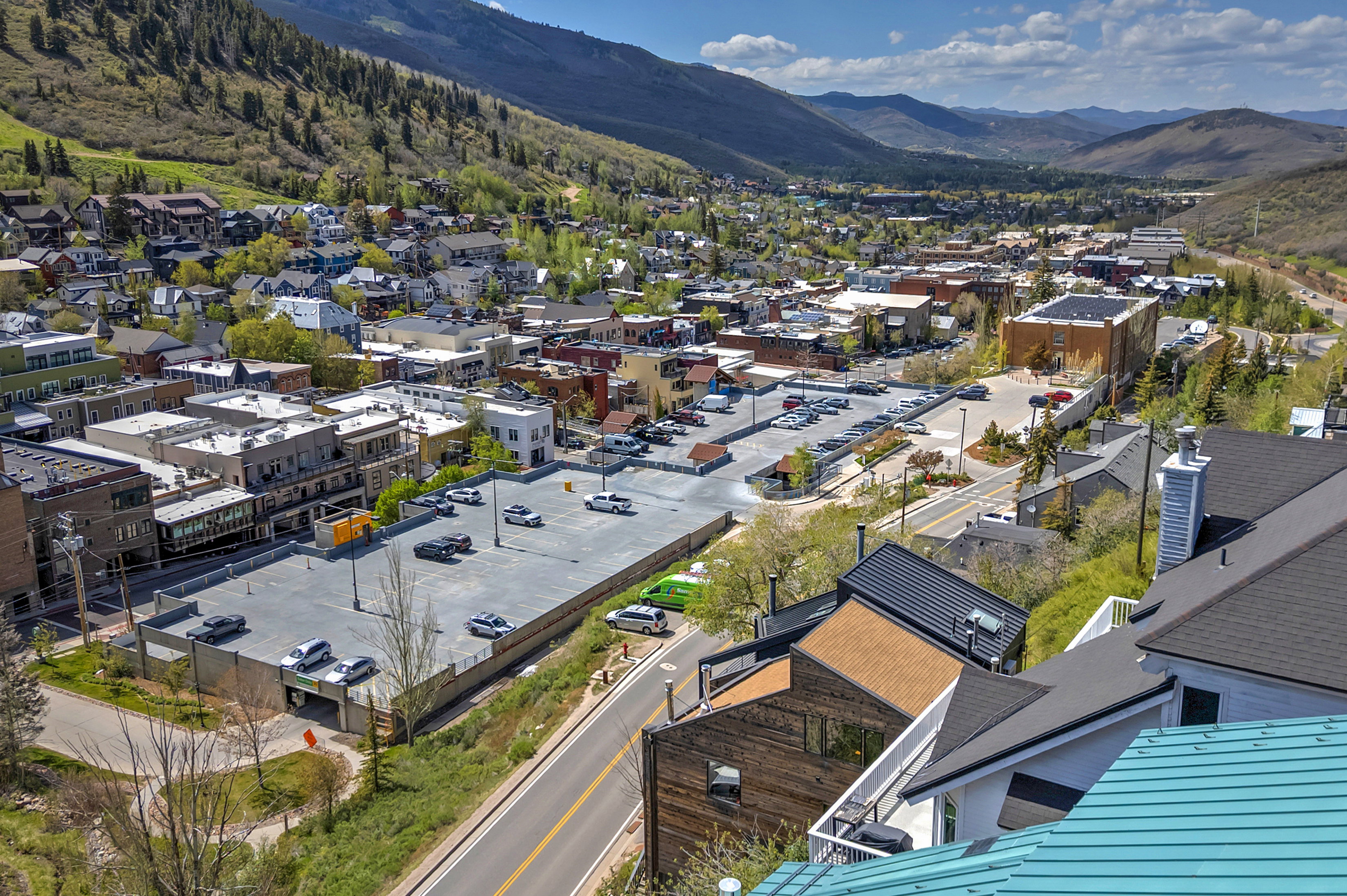 Expansive mountain valley landscape featuring a town, commercial buildings, and residential structures with varied rooflines