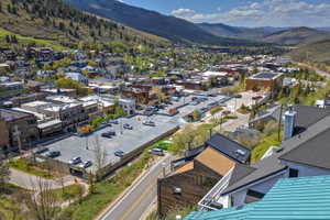 Expansive mountain valley landscape featuring a town, commercial buildings, and residential structures with varied rooflines