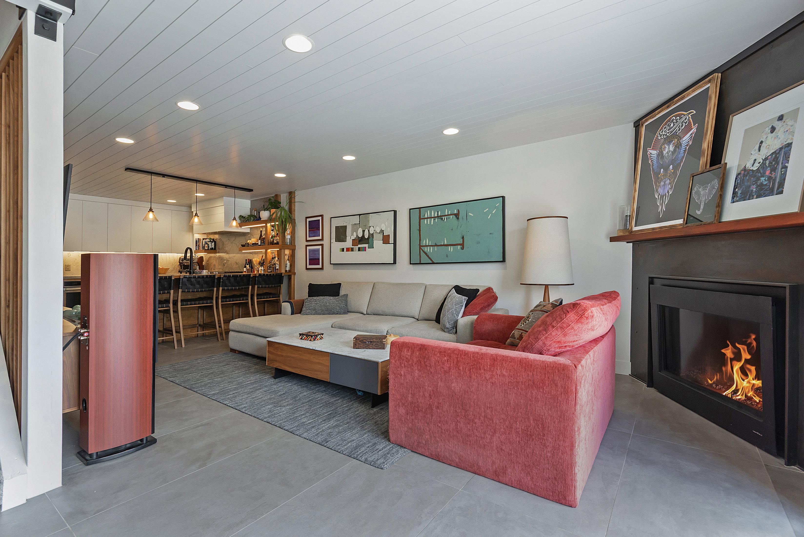 Open-concept living space featuring a built-in fireplace with a hearth, recessed ceiling lighting, and wood-finish accent walls