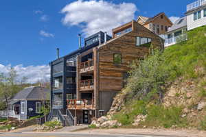 Contemporary multi-level exterior featuring dark paneled siding and natural wood cladding