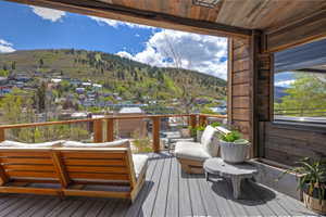 Expansive outdoor deck featuring wood-finish ceiling, wood-finish wall panels, gray composite decking, and a wood and cable railing system