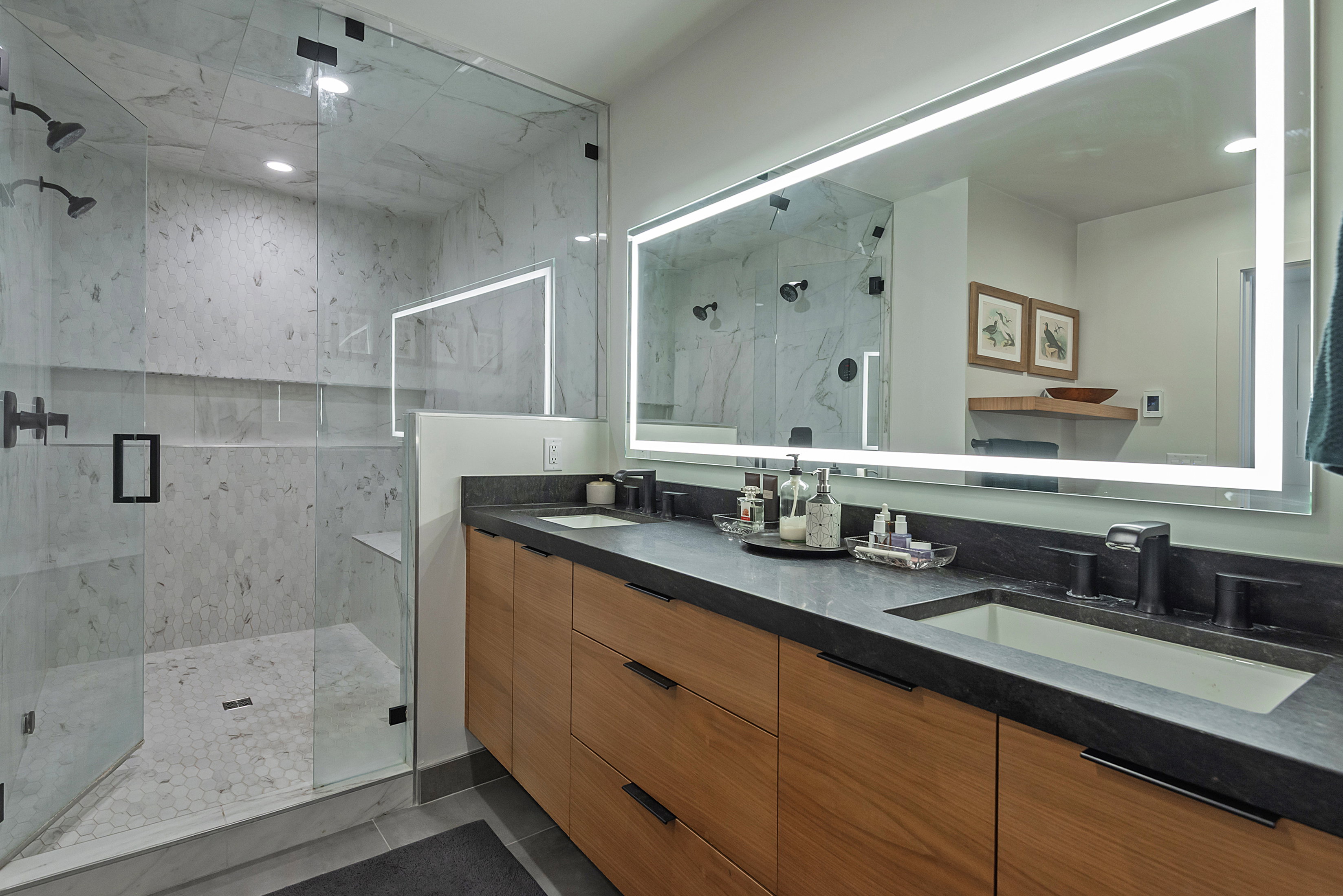 Walk-in shower with clear glass enclosure and dual shower heads