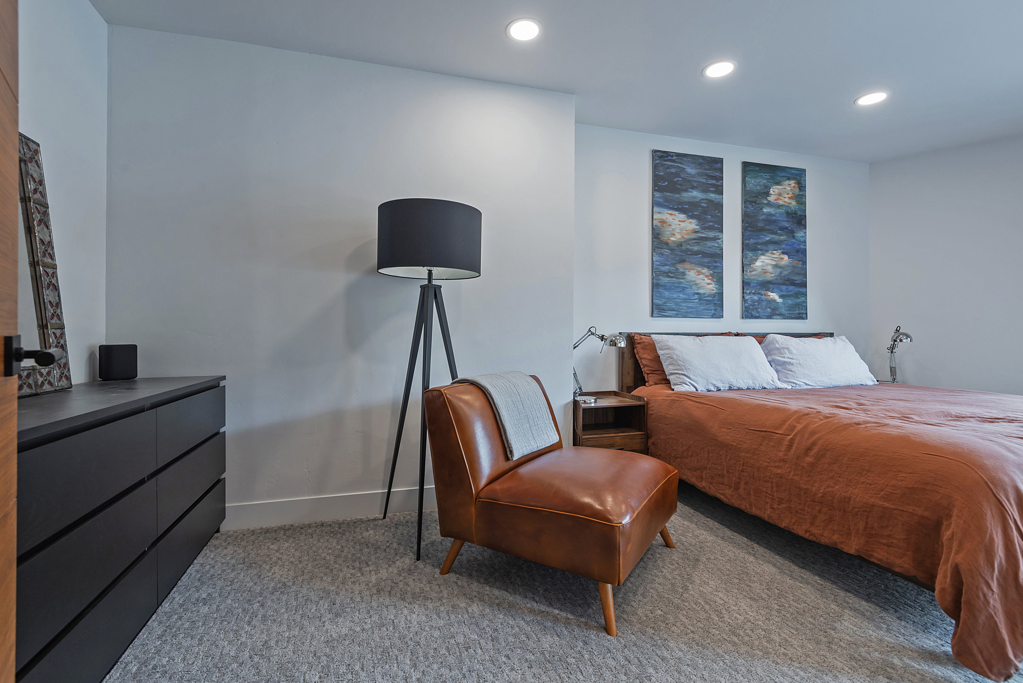 Recessed lighting illuminates the room with light gray carpeting