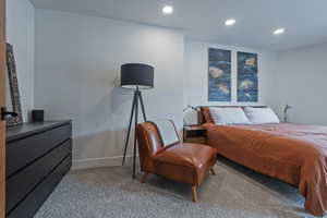 Recessed lighting illuminates the room with light gray carpeting