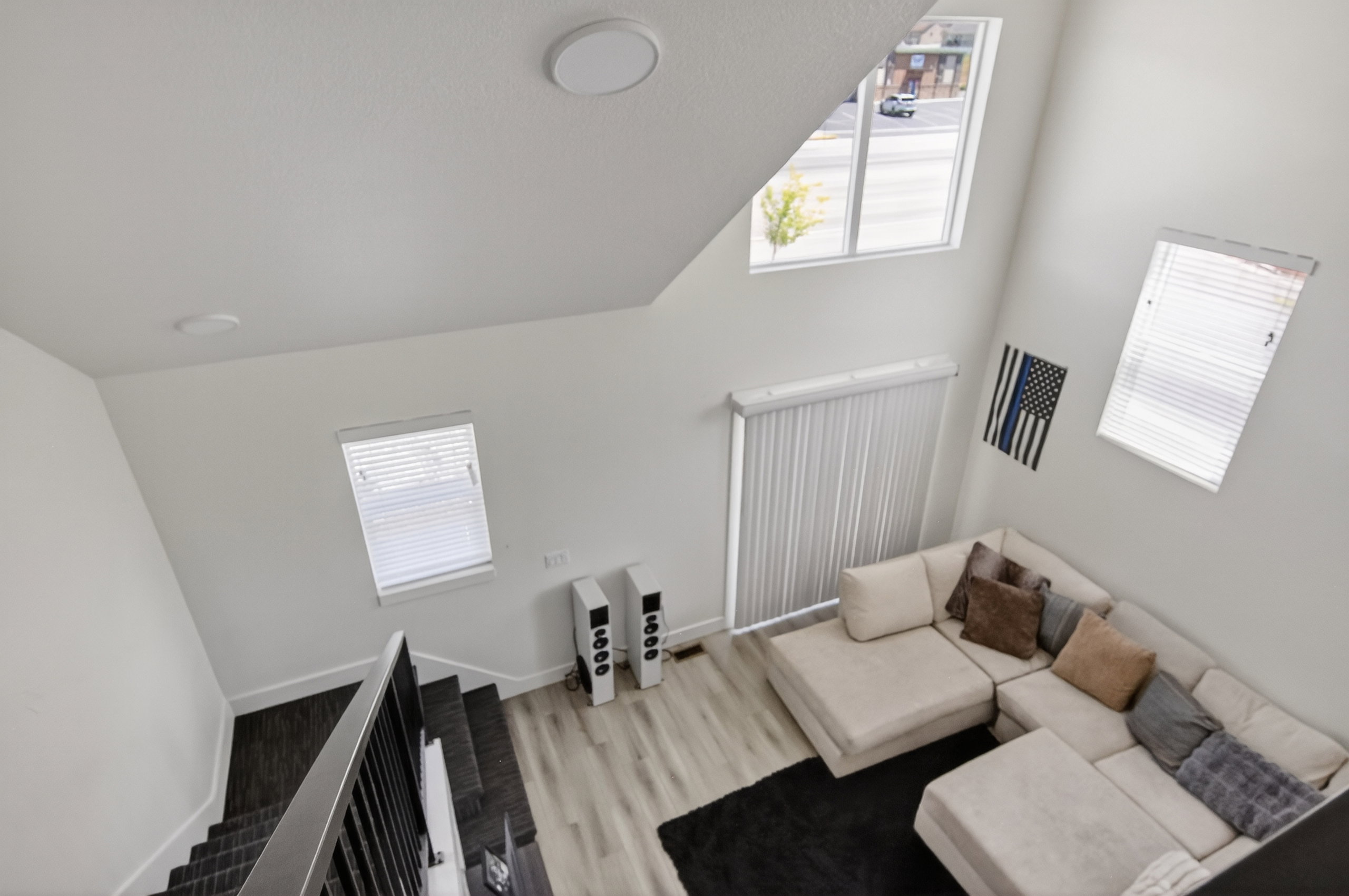 Soaring ceiling featuring multiple windows with blinds, recessed lighting, and wood-finish flooring