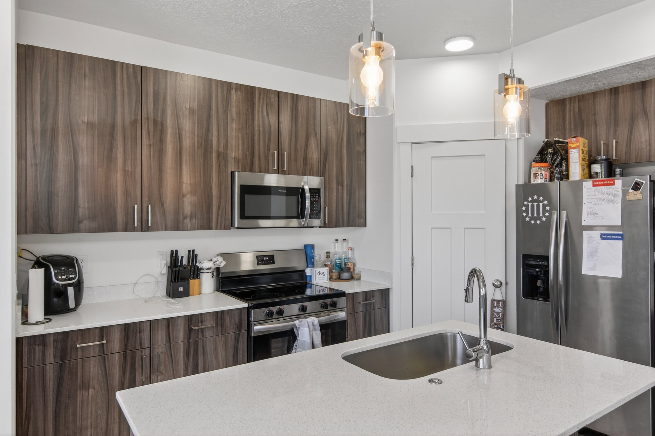 Kitchen featuring wood-finish cabinetry, stainless steel appliances, and quartz countertops