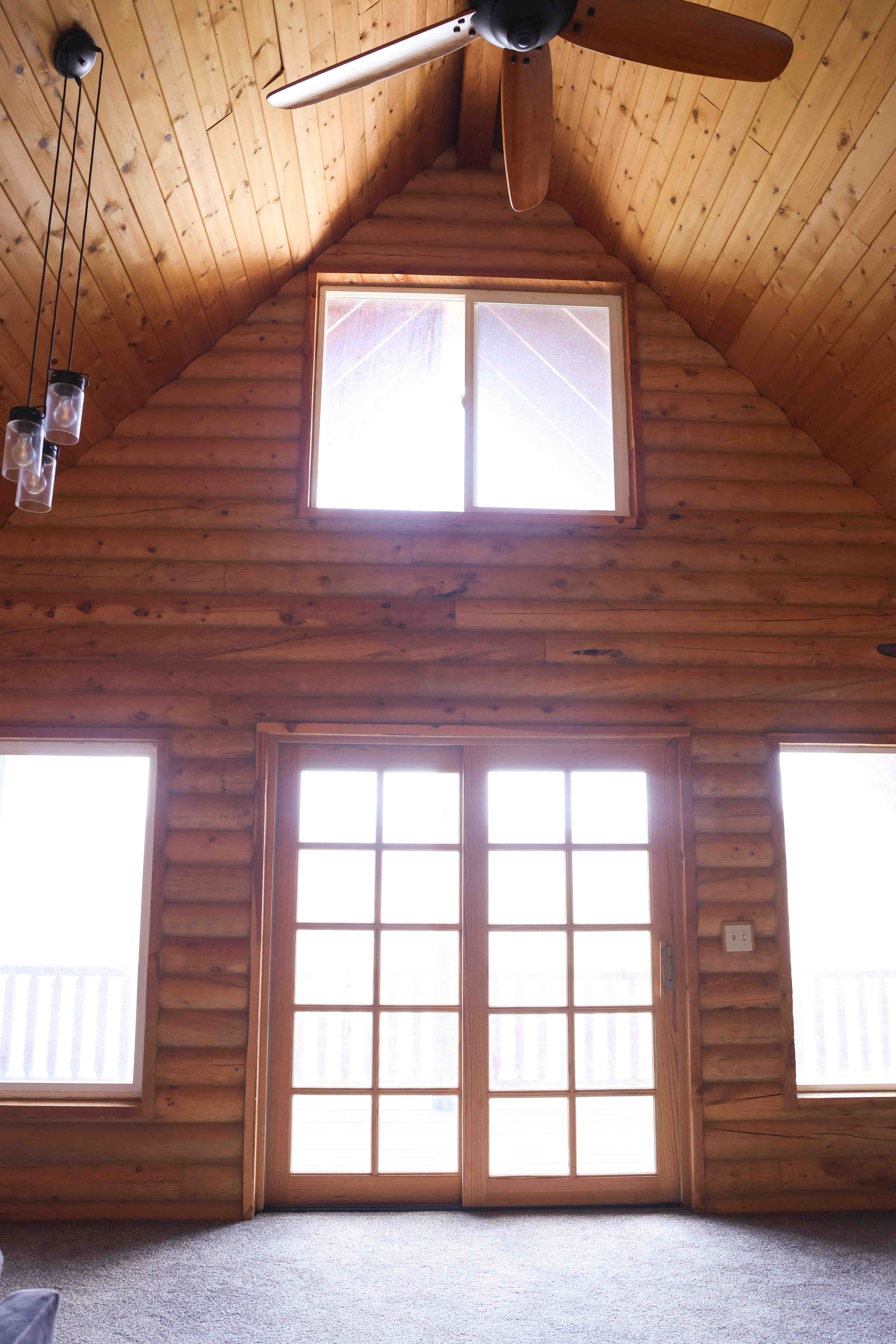 Vaulted wood-paneled ceiling with an exposed beam, featuring a ceiling fan