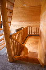 Rustic staircase featuring log-style railings and banisters