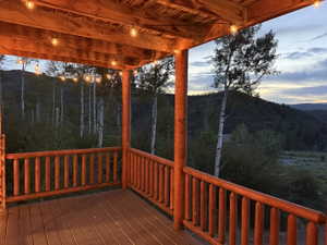 Covered outdoor deck featuring exposed wood beams and string lighting