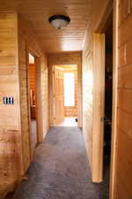 Wood-paneled hallway featuring matching wood doors and trim