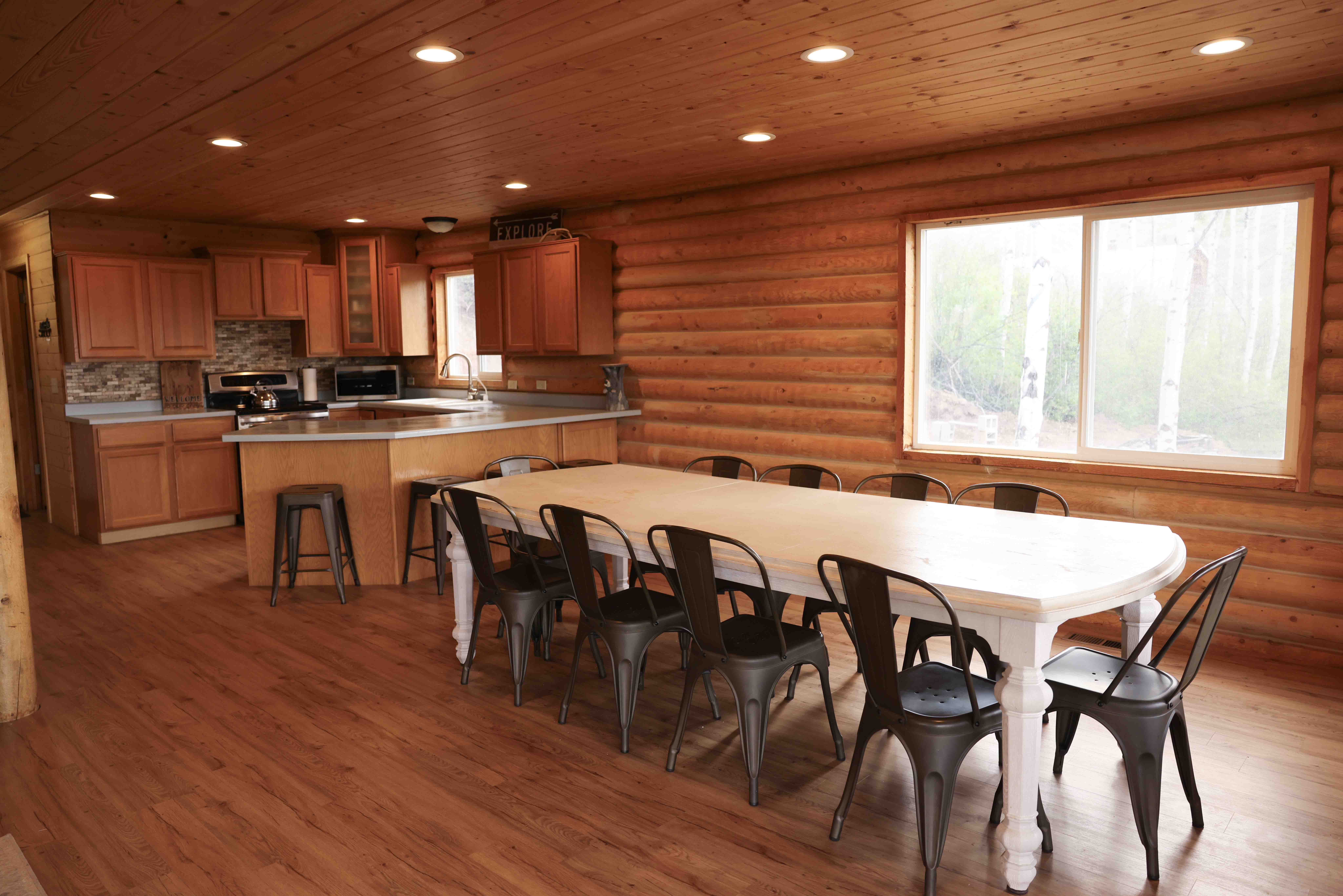 Expansive open-concept room featuring wood-finish flooring, recessed lighting, and a large window