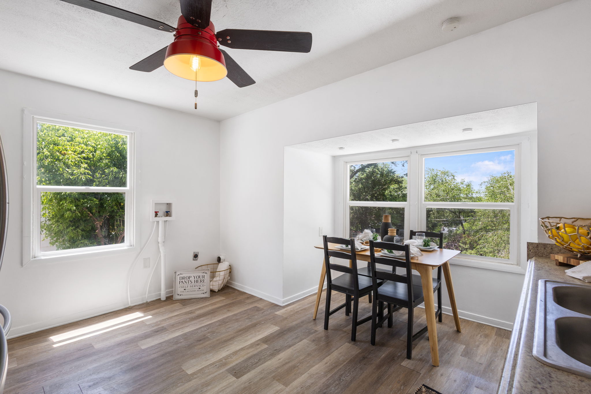 Bright dining area featuring LVP flooring, multiple large windows, and a built-in countertop extension