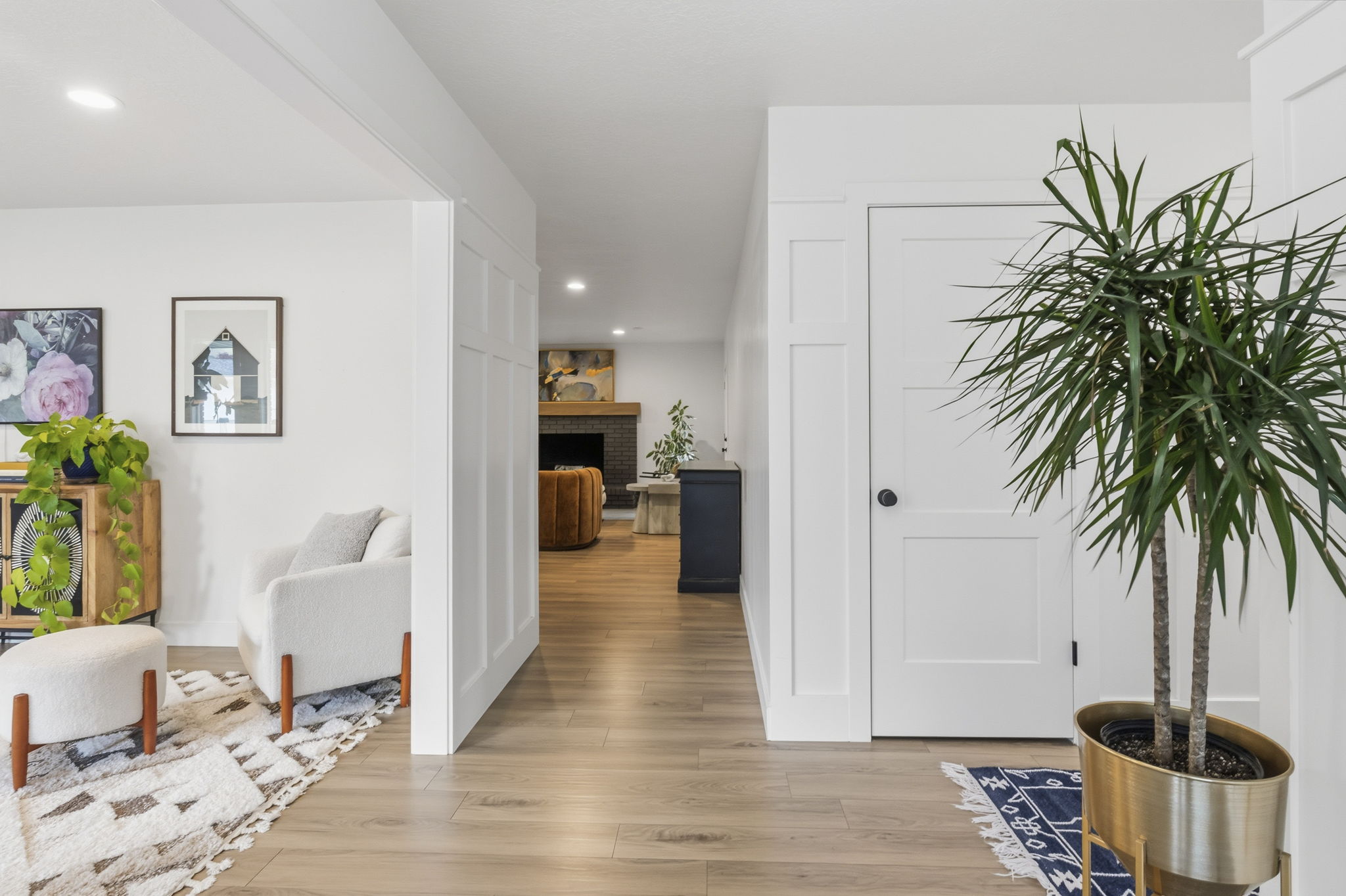 Light wood-finish flooring throughout, featuring crisp white walls and recessed lighting