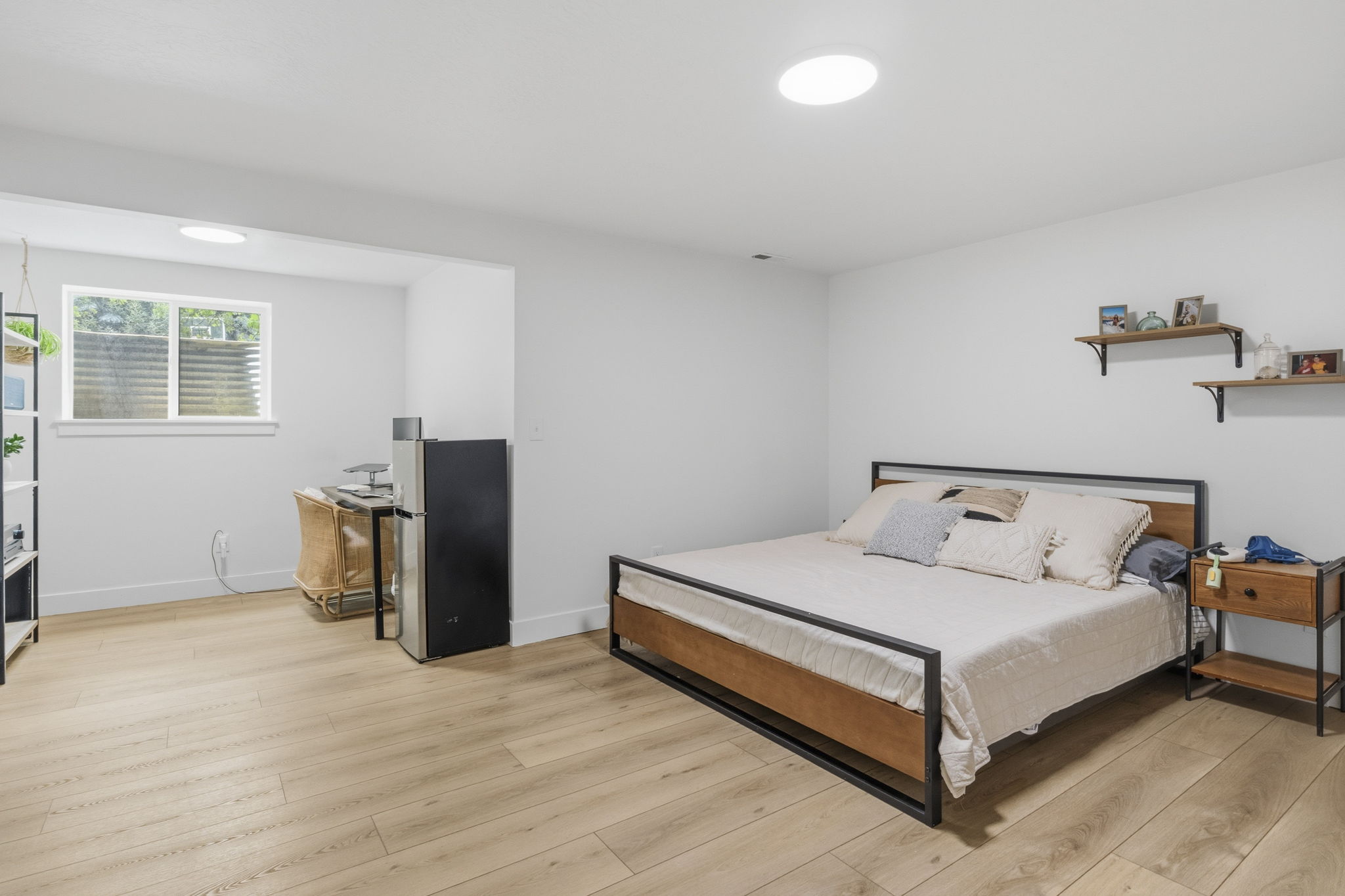 Spacious room with light wood-finish flooring, recessed lighting, and a window providing natural illumination