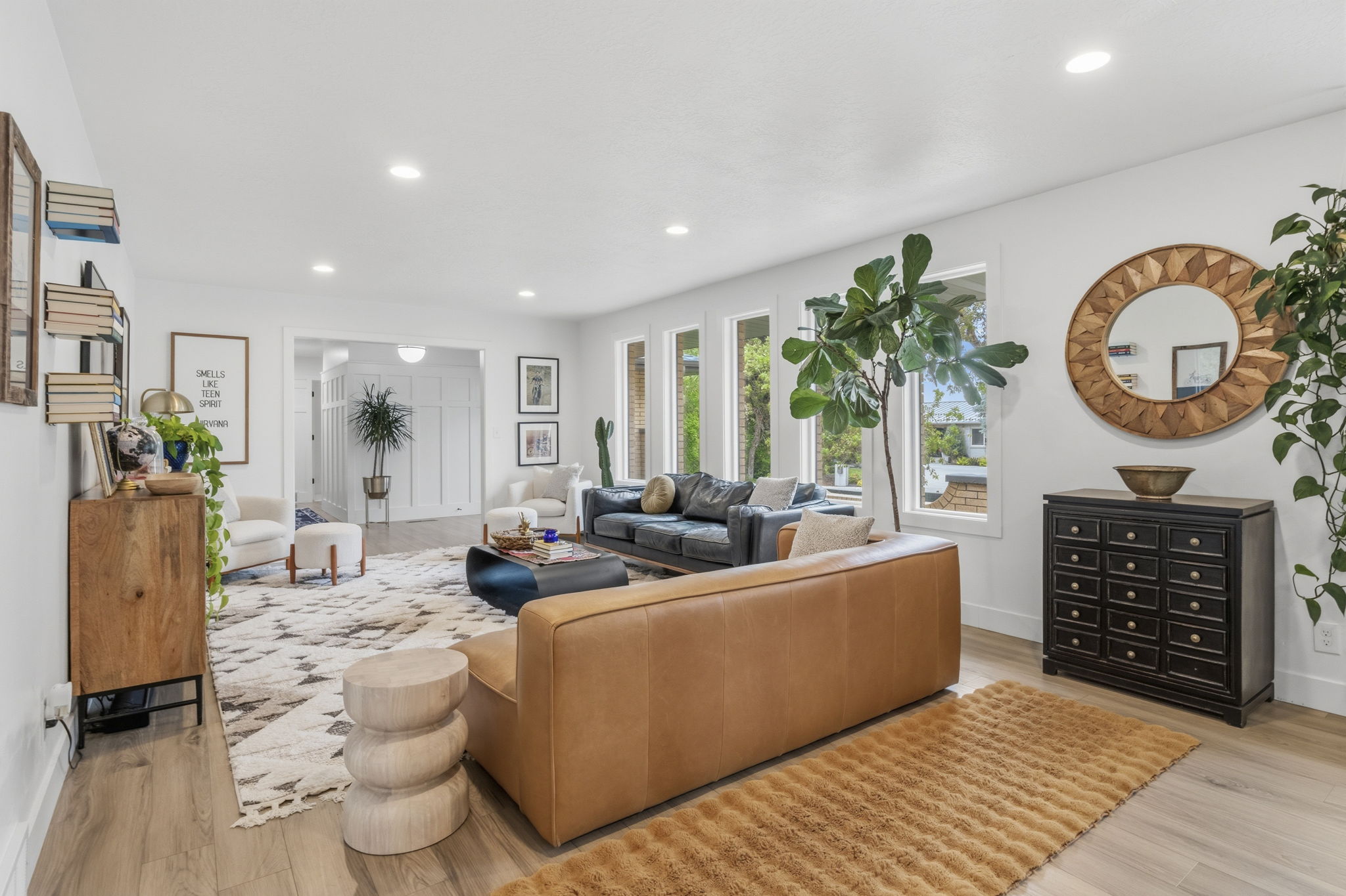 Spacious living area featuring light wood-finish flooring, recessed lighting, and multiple large windows