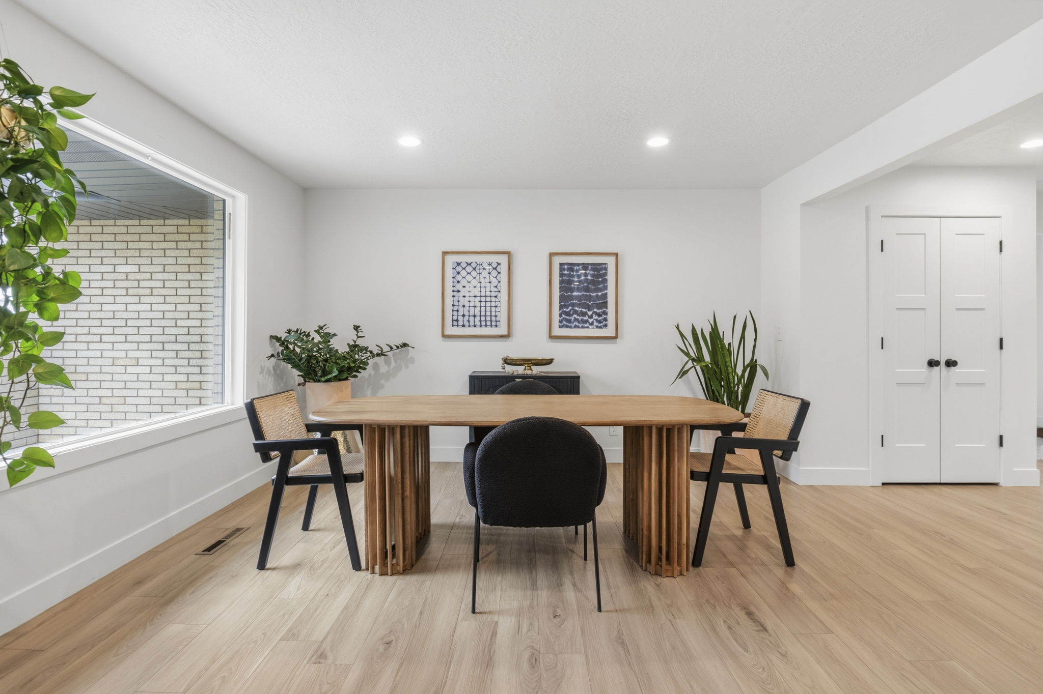 Light wood-finish flooring complements white walls and recessed lighting