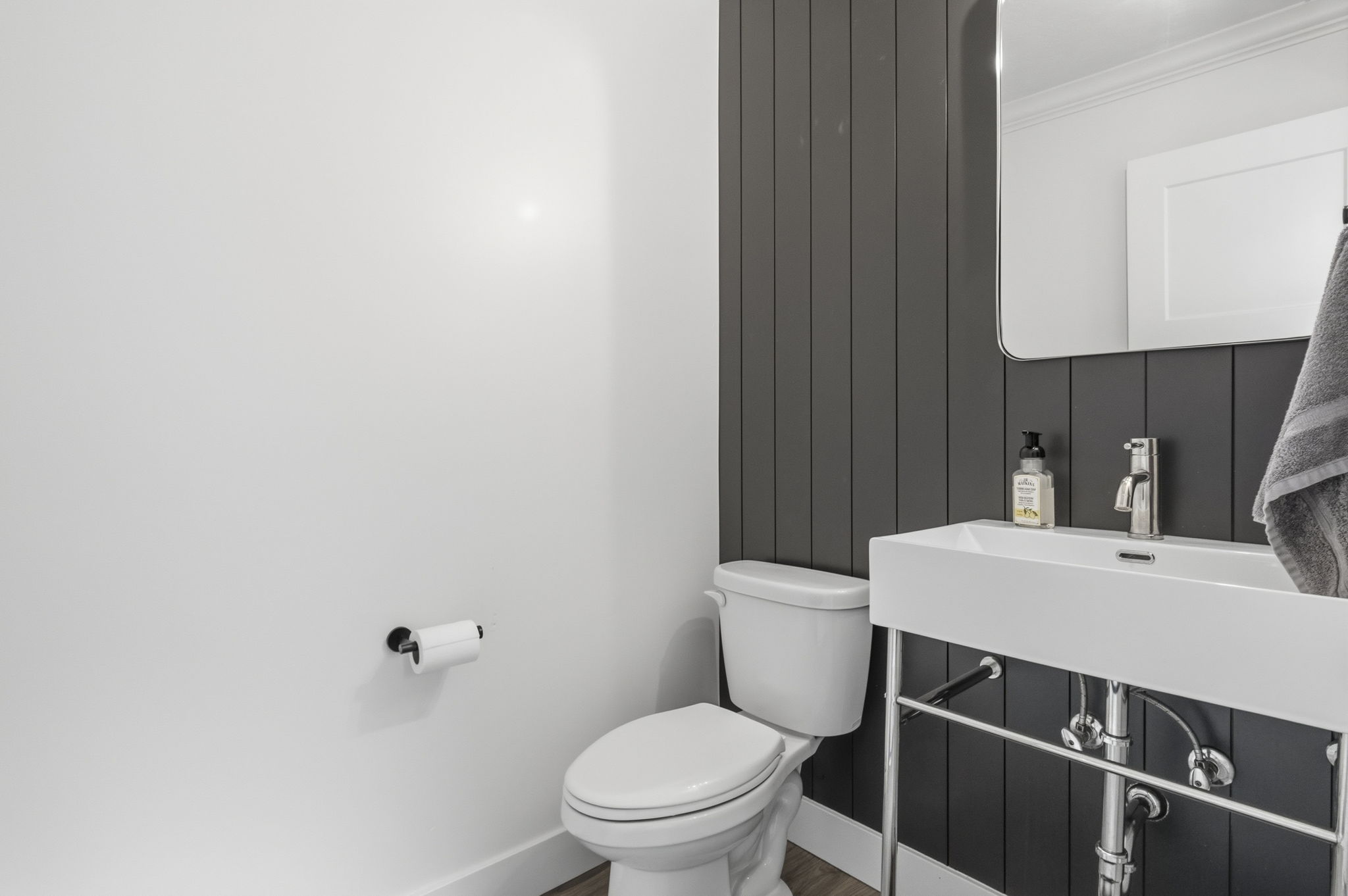 Contemporary powder room featuring a wall-mounted rectangular sink with chrome fixtures, a modern toilet, and a sleek rectangular mirror