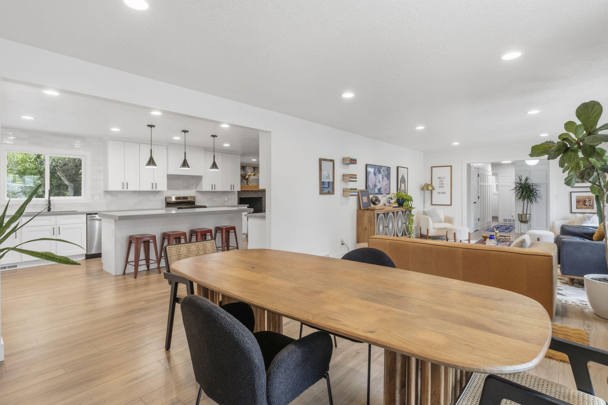 Open-concept living space featuring wood-finish flooring, recessed lighting, and a kitchen with white cabinetry