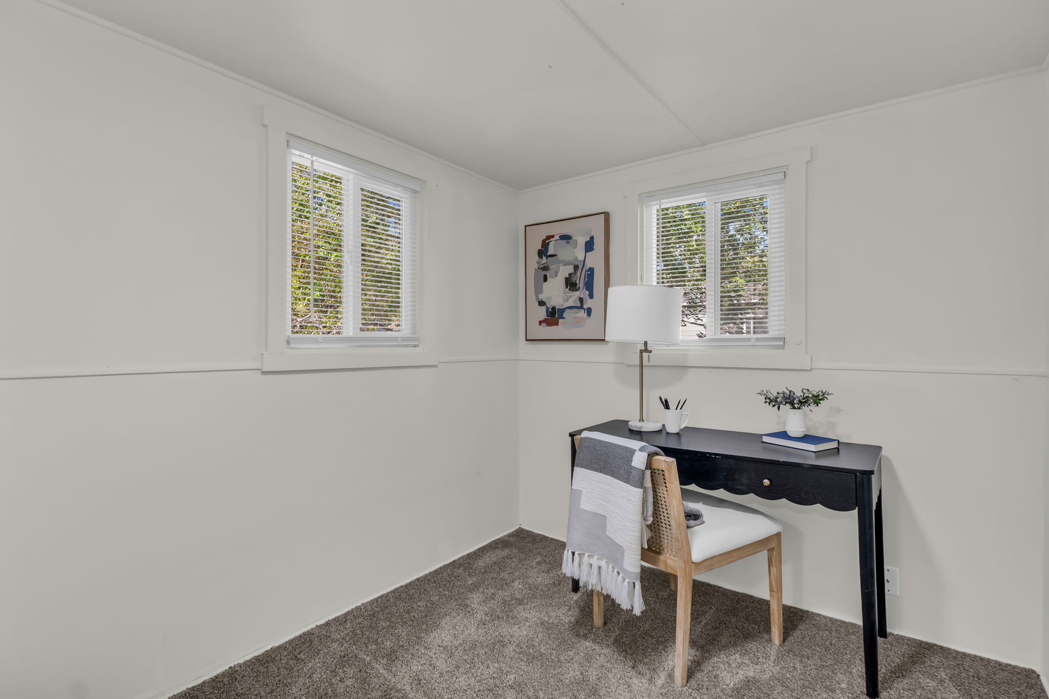 Light gray carpeting paired with white walls, baseboards, and window trim