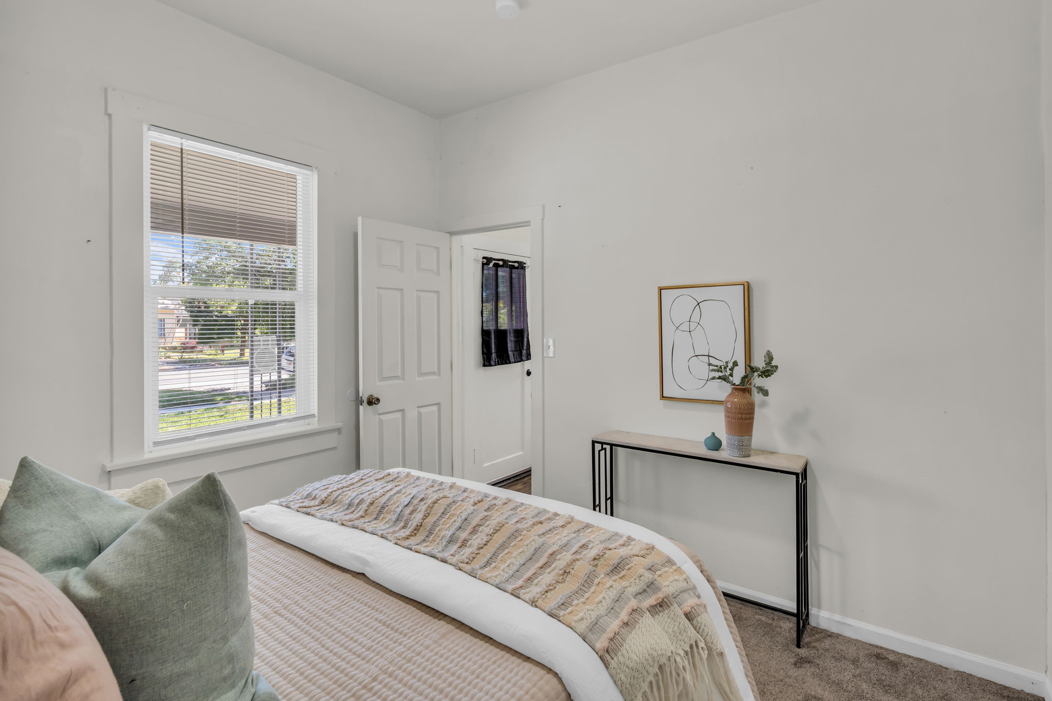 Carpeted room featuring a single window with blinds and white trim