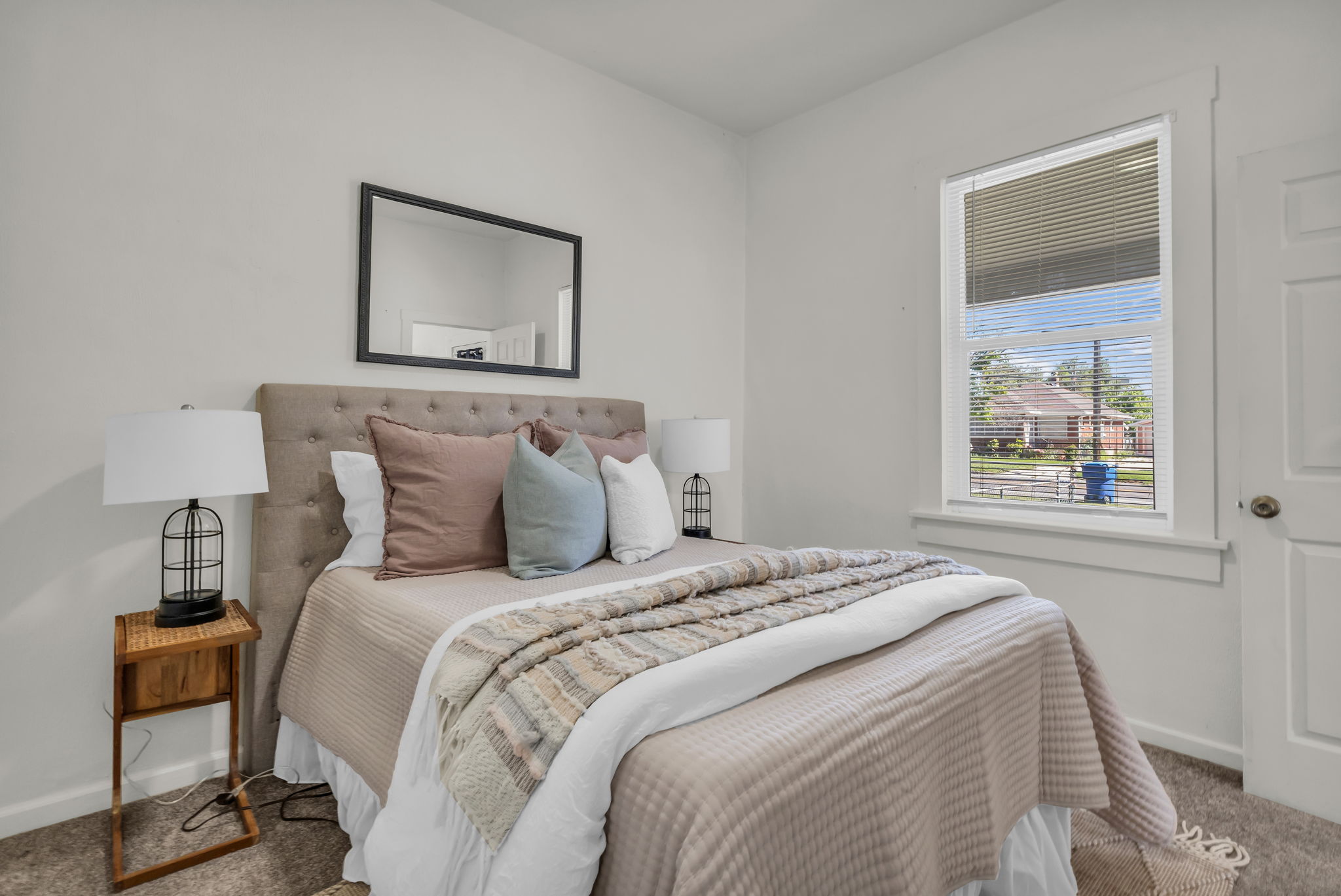 Bedroom featuring neutral wall paint, a single window with blinds, and white trim work