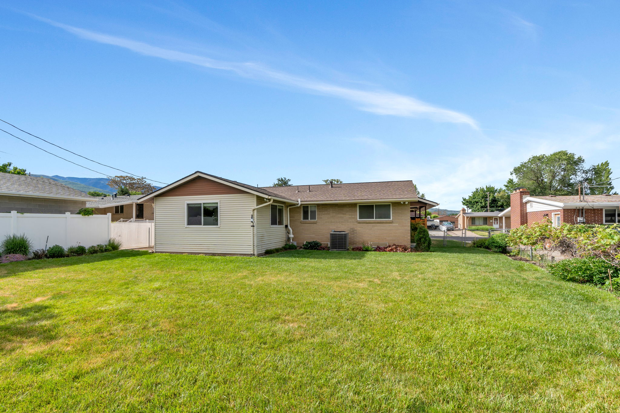 Expansive lawn with a white privacy fence
