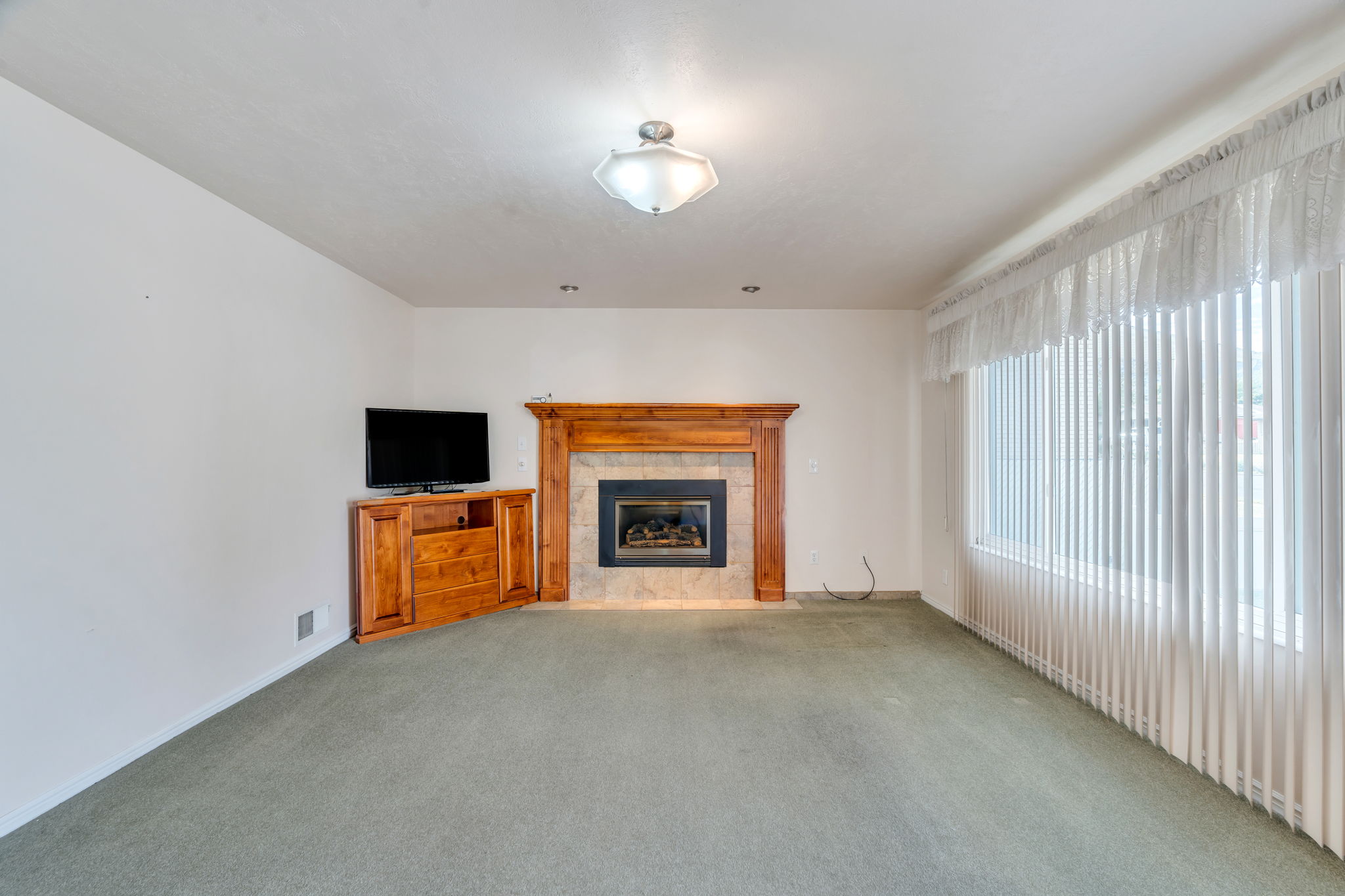 Living area featuring a fireplace with a wood mantle and tile surround