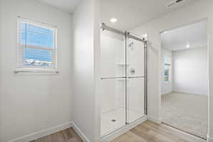 **Disclaimer**  Interior package may vary. Glass-enclosed shower with white subway tile surround and integrated shelving, featuring a chrome shower fixture