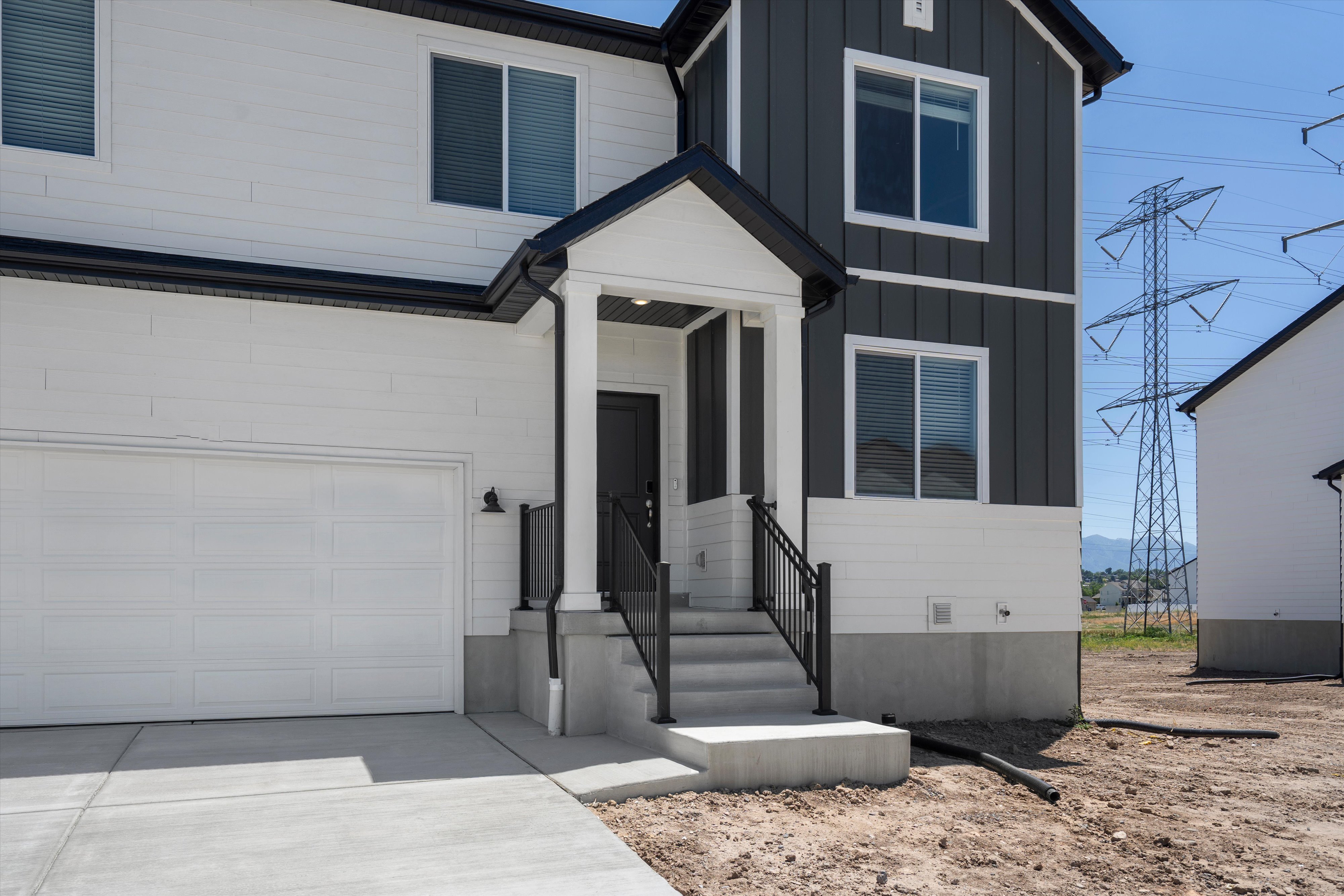 Contemporary two-story exterior featuring white horizontal siding and dark vertical siding accents