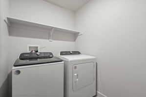 **Disclaimer**  Interior package may vary. Dedicated laundry area featuring a wall-mounted shelf, light-toned walls, and utility hookups