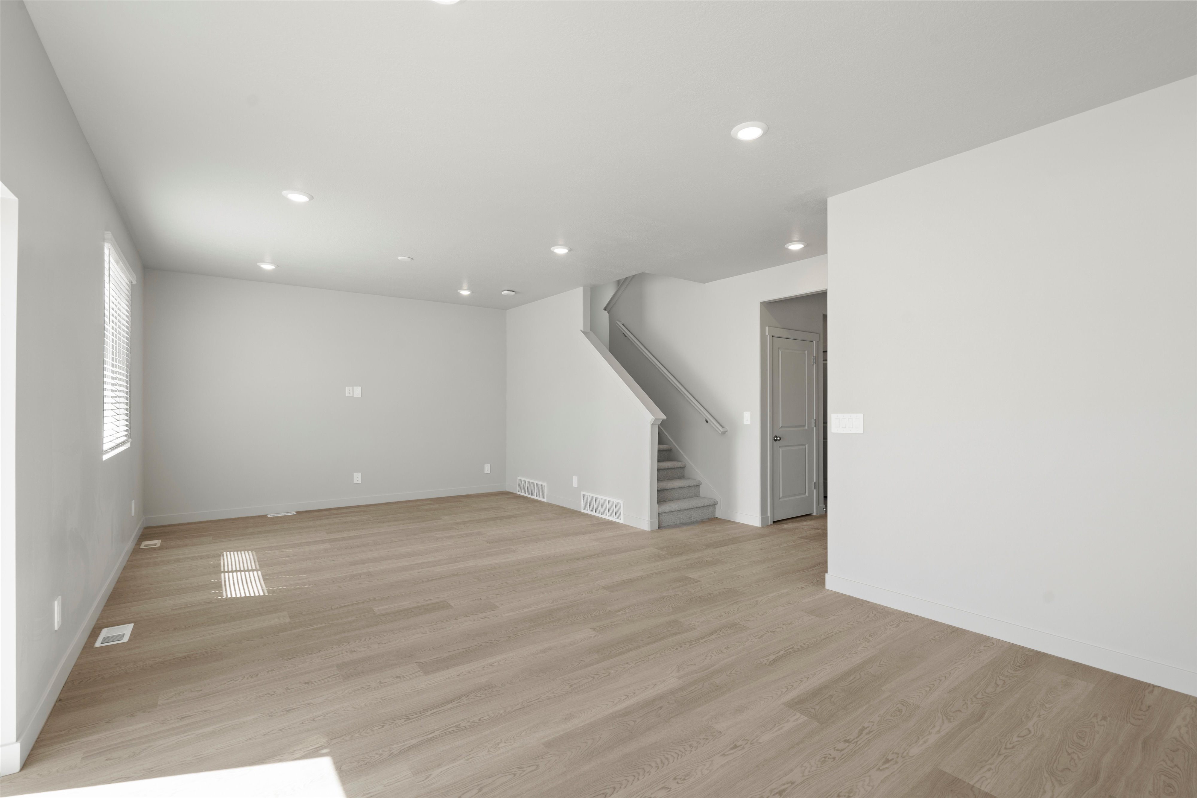 Spacious interior featuring light wood-finish flooring, recessed lighting, and neutral wall tones