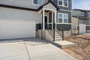 Modern two-story exterior featuring light gray siding and dark gray vertical siding accents