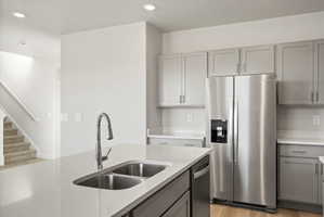 **Disclaimer**  Interior package may vary. Kitchen island with a double basin stainless steel sink, a chrome pull-down faucet, and light-toned countertops