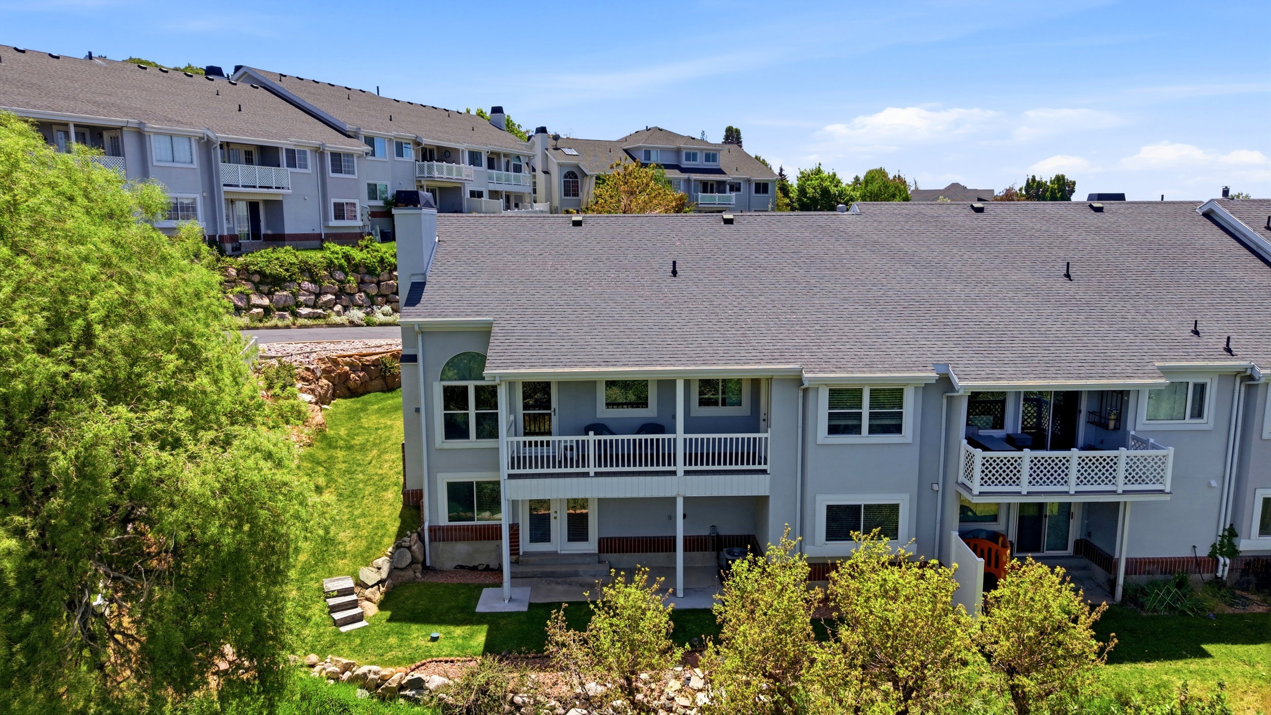 Rear exterior featuring a two-level design with balconies and patios