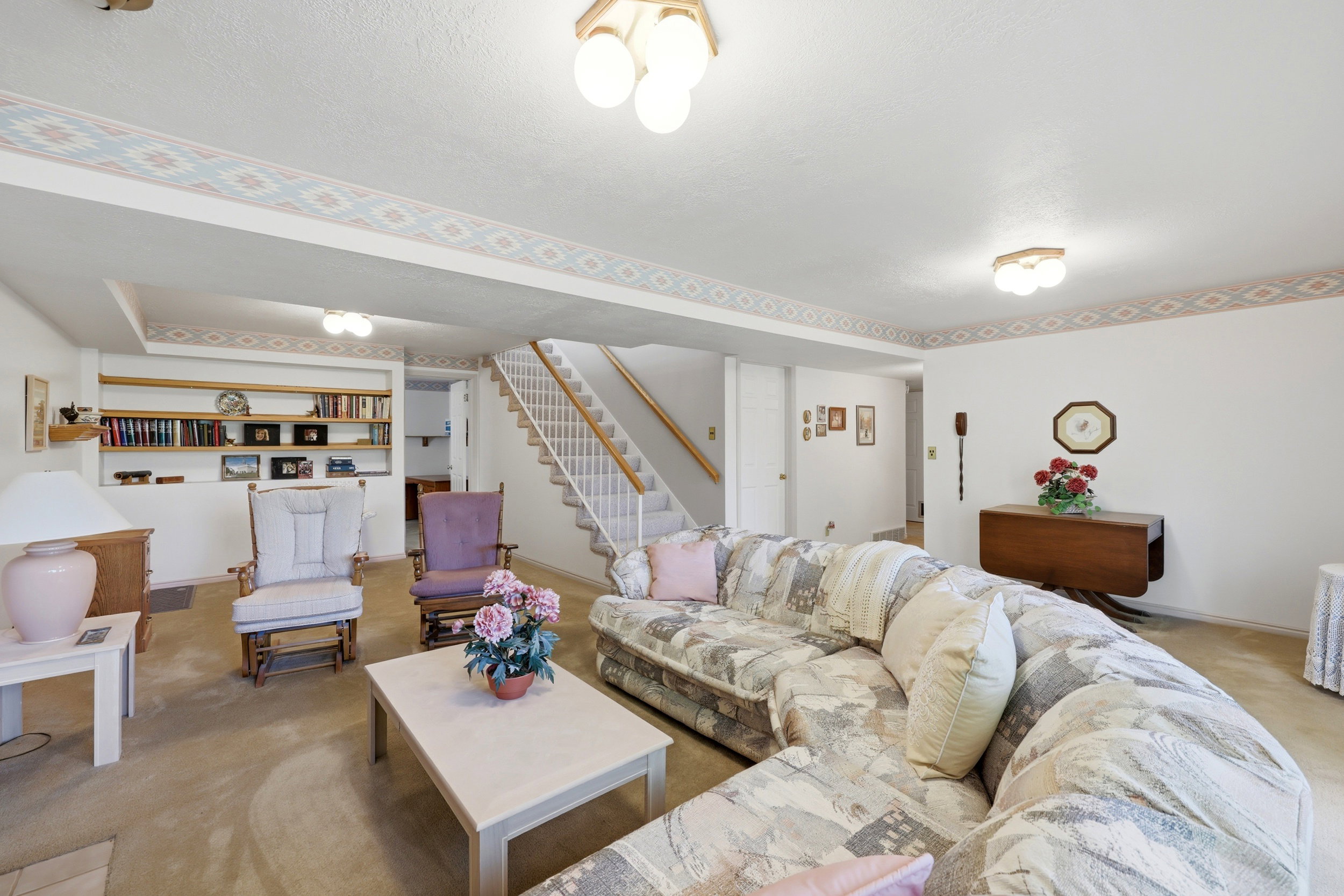 Spacious living area featuring carpet flooring and built-in shelving