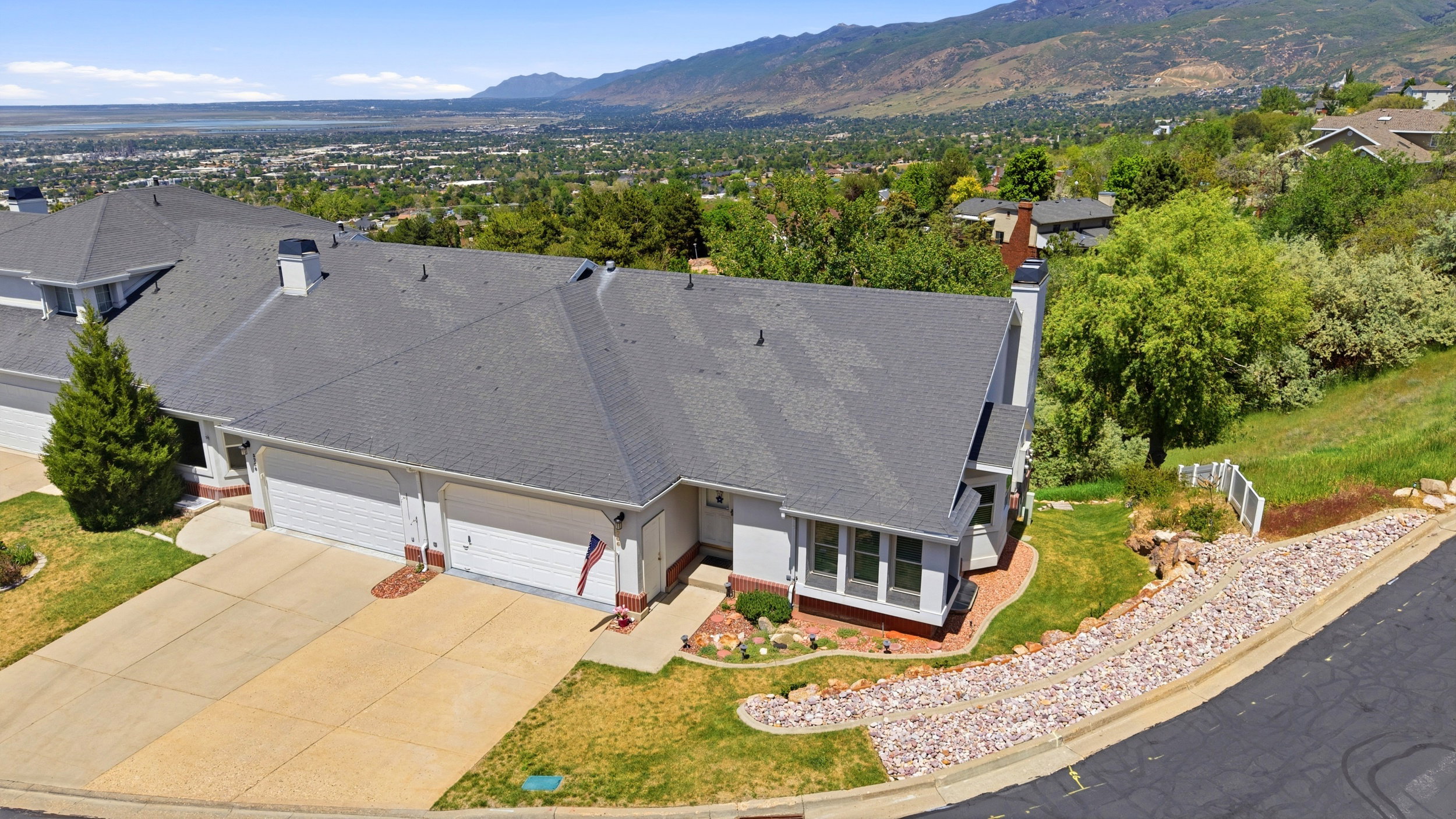 Single-story residence with a gray shingle roof, integrated two-car garage, and a concrete driveway