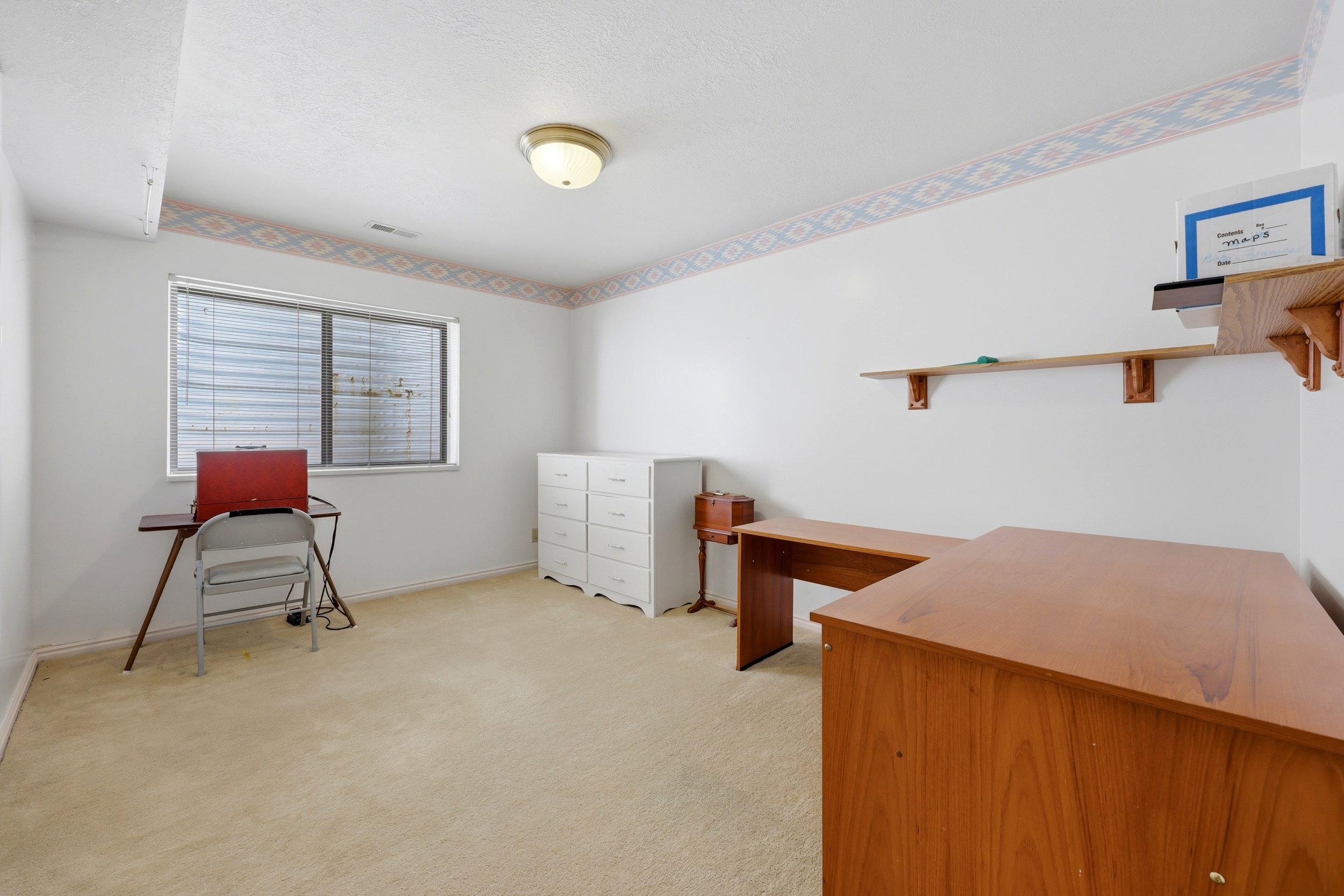 Carpeted room with a window featuring horizontal blinds