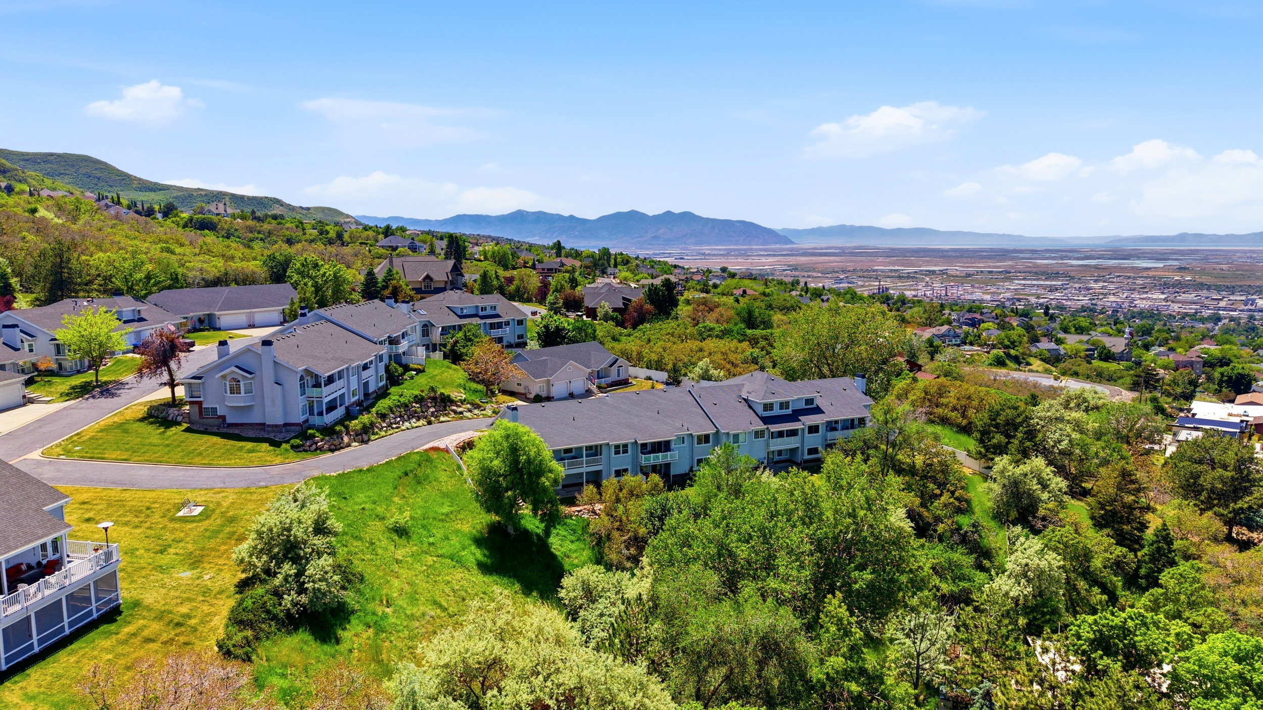 Hillside community featuring multiple residential structures with dark roofs and light-colored siding
