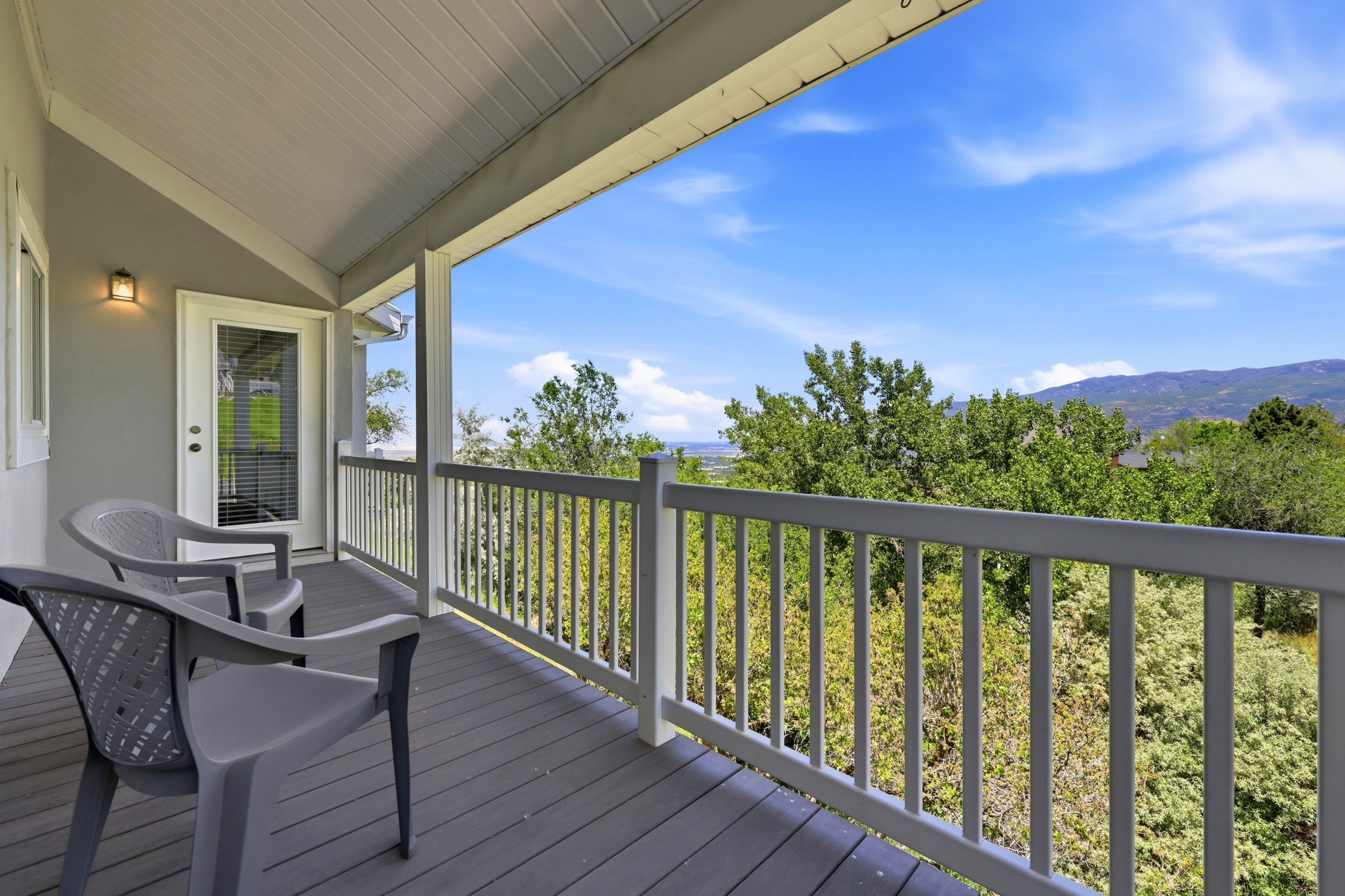 Covered balcony featuring a vaulted ceiling and composite decking