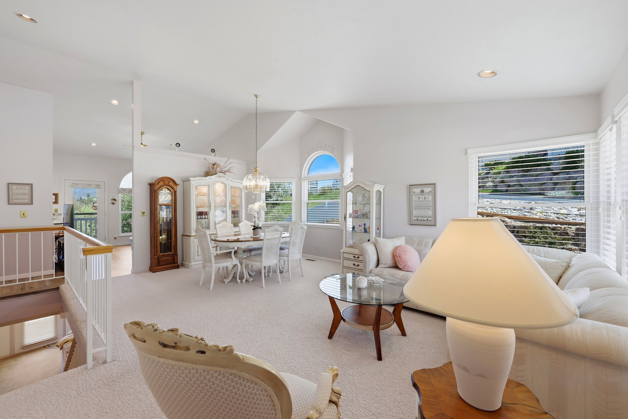 Bright living space featuring vaulted ceilings, a large picture window, recessed lighting, and a neutral carpet