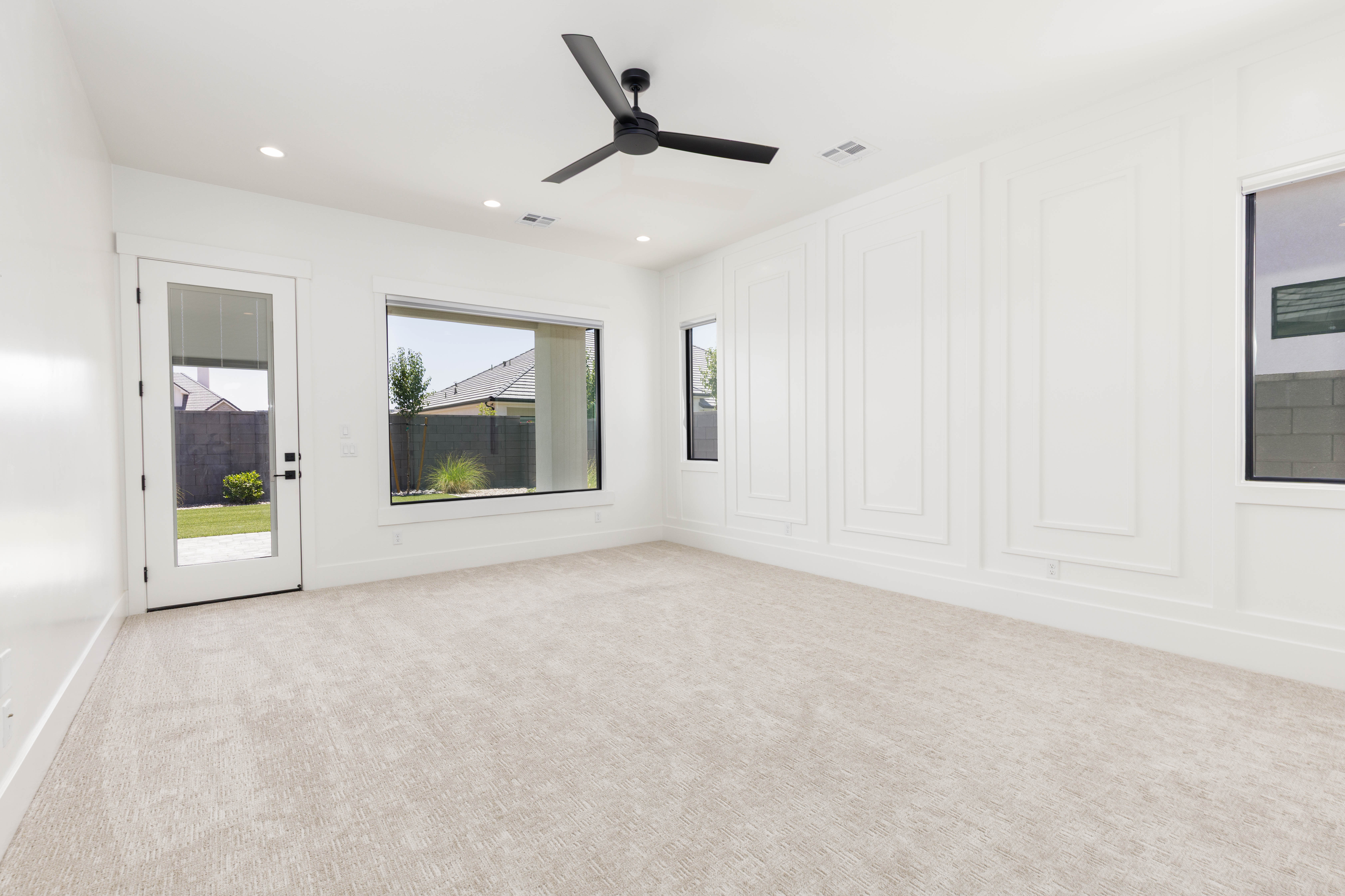 Spacious room featuring a decorative accent wall, recessed lighting, and a contemporary ceiling fan
