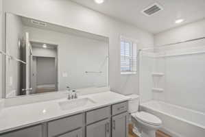 Bathroom featuring a vanity with an integrated sink, polished chrome faucet, and gray cabinetry