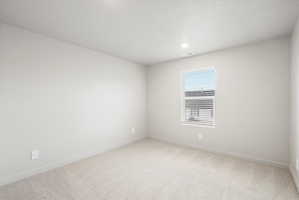 Room featuring light gray walls, neutral carpeting, a single window with white blinds, recessed lighting, and white baseboards