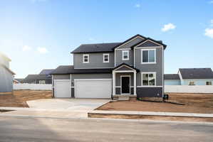 Contemporary two-story residence featuring grey siding, a black shingle roof, and a two-car attached garage