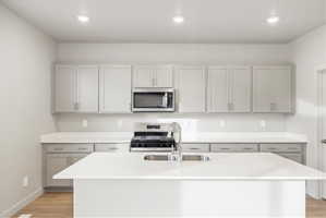 Kitchen featuring a central island with an undermount sink and gooseneck faucet