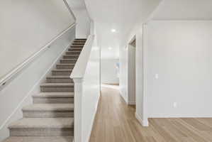 Staircase featuring carpeted treads and a painted handrail