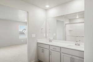 Bathroom featuring a dual vanity with light gray cabinetry, white countertops, and undermount sinks