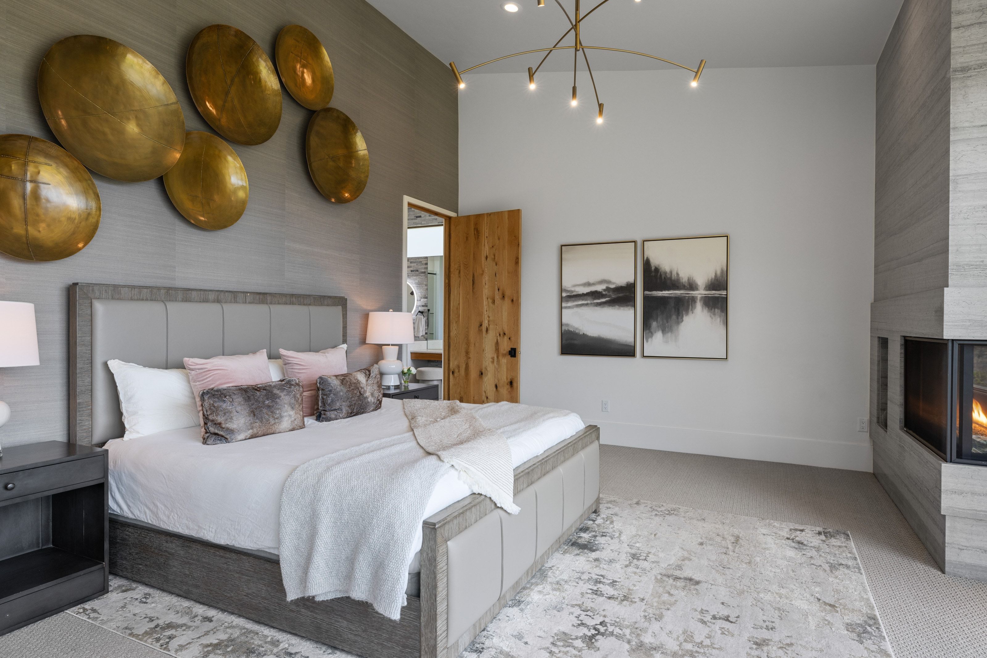 Spacious sleeping area featuring a vaulted ceiling and a stacked stone fireplace with a horizontal hearth